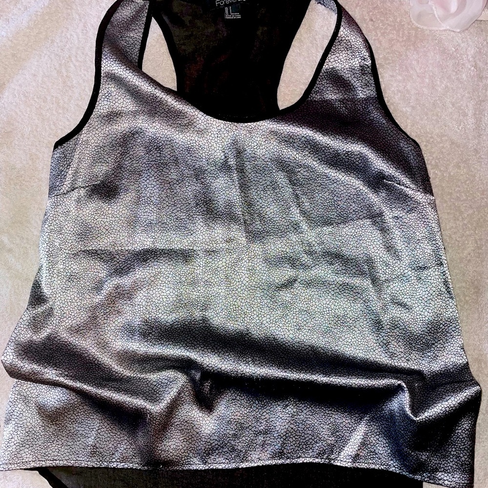 Metallic racer back tank top with sheer back. High low fit.